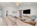 Spacious living room with neutral tones features vaulted ceiling, a barn door, and a comfortable sectional sofa at 1087 Piedmont Rd, Venice, FL 34293