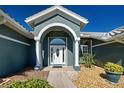 Close up of the inviting front entrance with white pillars and a decorative glass front door at 1125 Deardon Dr, Venice, FL 34292