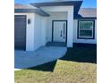 Welcoming front entrance with a modern design, featuring a covered porch and a well-maintained lawn at 12390 Talavera St, North Port, FL 34287