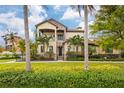 Beautiful two-story stucco home featuring stone accents, a balcony, and tropical landscaping at 158 E Tampa Ave, Venice, FL 34285