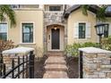Inviting home entrance with stone pillars, brick walkway, and a charming dark wood front door at 158 E Tampa Ave, Venice, FL 34285