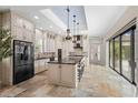 Spacious kitchen featuring an island, modern appliances, stone floors, and pendant lighting at 158 E Tampa Ave, Venice, FL 34285