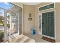 Covered front porch with screen door and verdant green door, and a blue vase at 1596 Monarch Dr # 1596, Venice, FL 34293