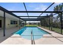 Inviting in-ground pool featuring a screened enclosure, ladder and surrounding patio area at 1726 Claw Ct, Venice, FL 34293