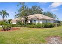 A home with lush landscaping, mature trees, and a barrel tile roof at 1995 White Feather Ln, Nokomis, FL 34275