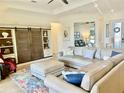 Bright living room with a neutral color palette and stylish built-in shelving with sliding wood doors at 20806 Valprato Ct, Venice, FL 34293