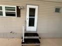 Side entrance featuring storm door, window, and outdoor light at 217 Mantua Dr, Venice, FL 34285