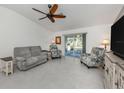 Neutral living area featuring tile floors, ceiling fan, and sliding doors to screened lanai at 2450 Sahara Ln, North Port, FL 34286
