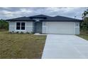 Charming single-story home with a well-manicured lawn and a two-car garage at 2643 Orchard Cir, North Port, FL 34288