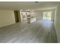 Spacious living room featuring tile floors, recessed lighting, and sliding door access to the backyard at 2643 Orchard Cir, North Port, FL 34288