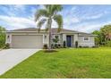 Charming single-story home featuring a manicured lawn, an attached garage, and tasteful landscaping at 2694 Hopwood Rd, North Port, FL 34287