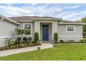 Close-up of a home's front entrance with blue door, walkway, and professionally landscaped garden beds at 2694 Hopwood Rd, North Port, FL 34287