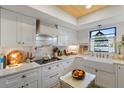 Bright kitchen featuring white cabinets, farmhouse sink, and modern appliances, creating a charming and functional space at 3641 Longmeadow # 33, Sarasota, FL 34235