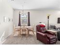 Inviting dining area with natural light, carpet flooring, and a view to the living room at 3691 Parkridge Cir # 201, Sarasota, FL 34243