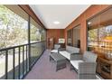 Spacious balcony with seating, wood paneled walls, and screened windows at 4260 Placida Rd # 25D, Englewood, FL 34224