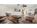 Spacious living area featuring wood floors, comfortable seating, and an open layout leading to the kitchen and dining area at 427 Canterbury Rd, Venice, FL 34293