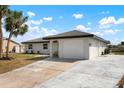 Single-story home featuring a clean white exterior, an attached garage, and a concrete driveway at 4740 Payne St, North Port, FL 34287