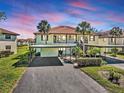 Inviting condo with a red tile roof, lush landscaping, and convenient covered parking at 503 Pine Hollow Cir # 503, Englewood, FL 34223