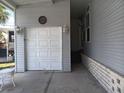 Attached garage featuring a classic white door and decorative outdoor lighting at 601 Club House Rd, Venice, FL 34285