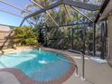Inviting screened-in pool with refreshing blue water, a soothing waterfall feature, and a convenient outdoor shower at 613 Sugarwood Dr, Venice, FL 34292