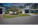 Charming single-story home featuring a screened-in porch, blue trim and mature tree in yard at 616 Circlewood Dr # S2-14, Venice, FL 34293