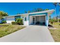 Charming single-story home featuring a screened-in porch, blue trim and well-maintained landscaping at 616 Circlewood Dr # S2-14, Venice, FL 34293