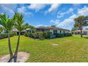 Green backyard with a view of the home's screened in patio and manicured perimeter hedges at 761 Vivienda South Ct # 14, Venice, FL 34293