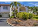 Well maintained condo building with tropical plants, landscaping, and manicured lawn at 820 Capri Isles Blvd # 202, Venice, FL 34292