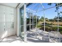 Inviting screened patio with white seating and serene views of the natural landscape at 835 Chalmers Dr # 835, Venice, FL 34293