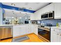 Bright kitchen featuring white cabinetry, stainless steel appliances, and modern backsplash at 838 Bird Bay Way # 114, Venice, FL 34285