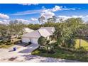 Beautiful aerial view of a well-maintained home with lush landscaping, three-car garage, and serene surroundings at 921 Tartan Dr # 31, Venice, FL 34293