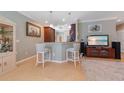 An open-concept eat-in kitchen with bar stool seating, pendant lights, and an adjacent living area at 9839 Nostalgia Pl, Englewood, FL 34223