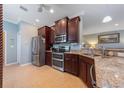 Lovely kitchen featuring dark cabinets, stainless steel appliances, granite countertops and tiled floors at 9839 Nostalgia Pl, Englewood, FL 34223
