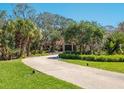 Long driveway leading up to this luxurious house with lush greenery at 1049 N Casey Key Rd, Osprey, FL 34229