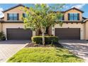 Home exterior with a well-manicured lawn, brick paved driveways, lush landscaping, and a two-car garage at 10797 Tarflower Dr # 202, Venice, FL 34293