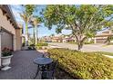 Charming street view with brick paved driveways, lush landscaping, and palm trees lining the road at 10797 Tarflower Dr # 202, Venice, FL 34293