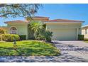 Inviting single-story home featuring well-maintained landscaping, paver driveway, and an attached two-car garage at 108 Corte Del Asolo, Venice, FL 34285