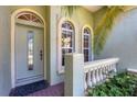 Charming front porch featuring decorative windows, a patterned glass door, and a balustrade at 108 Corte Del Asolo, Venice, FL 34285