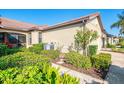 Side exterior view of the home showing landscaping and screened-in patio at 11157 Batello Dr, Venice, FL 34292
