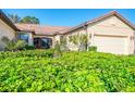 Lush landscaping surrounds this beautiful single-story home and enclosed patio at 11157 Batello Dr, Venice, FL 34292