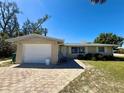 Cozy single-story home with a brick driveway, attached garage, and well-maintained front lawn at 1170 Little Ct, Englewood, FL 34223