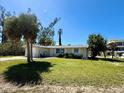 Inviting one-story home featuring a lush green lawn and mature trees in a serene setting at 1170 Little Ct, Englewood, FL 34223