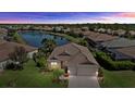 An aerial view of a home overlooking a serene pond with lush greenery at 12127 Granite Woods Loop, Venice, FL 34292