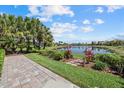 Scenic backyard view of a lake framed by lush greenery and a paved patio at 12127 Granite Woods Loop, Venice, FL 34292