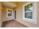 Cozy front porch with brick floor, seating, and a well-lit entry; perfect for relaxing at 12198 Sebring Ln, Venice, FL 34293