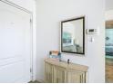Tastefully decorated entryway with elegant console table, mirror and charming beach decor at 1255 Tarpon Center Dr # 503, Venice, FL 34285