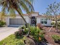 Charming home with a tile roof and meticulously landscaped front yard with vibrant tropical plants at 142 Braemar Ave, Venice, FL 34293