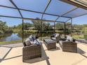 Screened lanai with comfortable outdoor seating, overlooking a tranquil pond with a beautiful view at 142 Braemar Ave, Venice, FL 34293