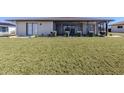 Expansive backyard featuring lush green grass and a covered patio perfect for outdoor living at 1602 Jim Jim Ct, Venice, FL 34293