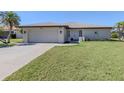 The exterior of this inviting home features a well-manicured lawn, a paved driveway, and an attached garage at 1602 Jim Jim Ct, Venice, FL 34293